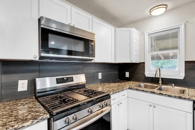 a kitchen with granite countertop a stove and a sink