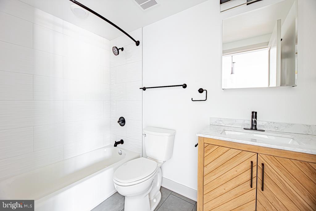 5001 Umbria Street, Unit U400 Philadelphia, PA 19128 - Photo 7 of 11 a bathroom with a granite countertop sink toilet and shower