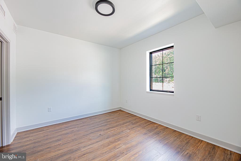 5001 Umbria Street, Unit U400 Philadelphia, PA 19128 - Photo 8 of 11 an empty room with wooden floor and windows
