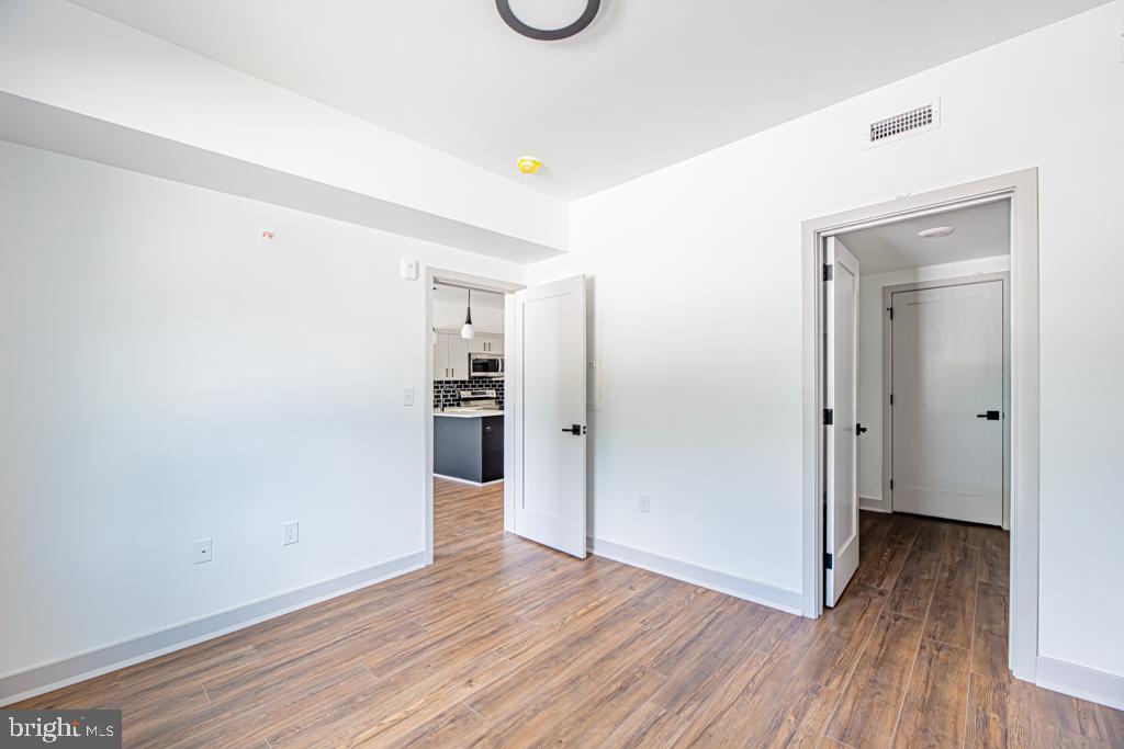 5001 Umbria Street, Unit U400 Philadelphia, PA 19128 - Photo 9 of 11 a view of a room with wooden floor and white doors