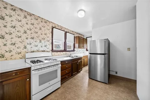 a kitchen with a stove top oven and refrigerator