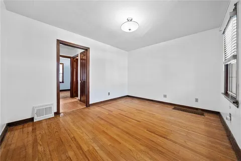 a view of a room with wooden floor and a window