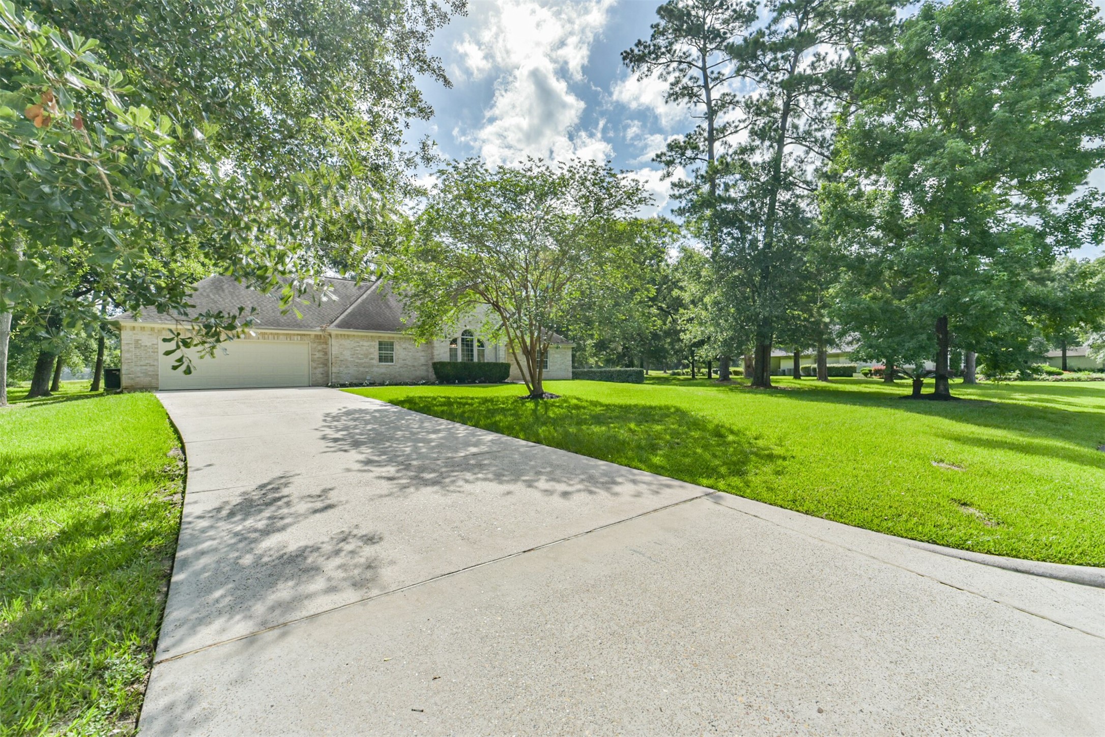 27322 Afton Way Huffman, TX 77336 - Photo 8 of 50 Grand circular driveway welcomes you to this beautifully maintained estate nestled on a sprawling, tree-lined lot.