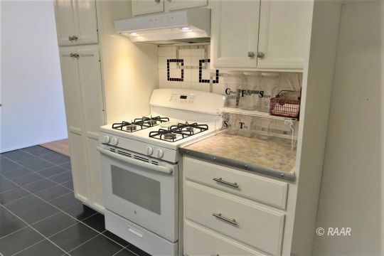 1263 Primrose Street Ridgecrest, CA 93555 - Photo 10 of 35 a kitchen with granite countertop white cabinets and white appliances