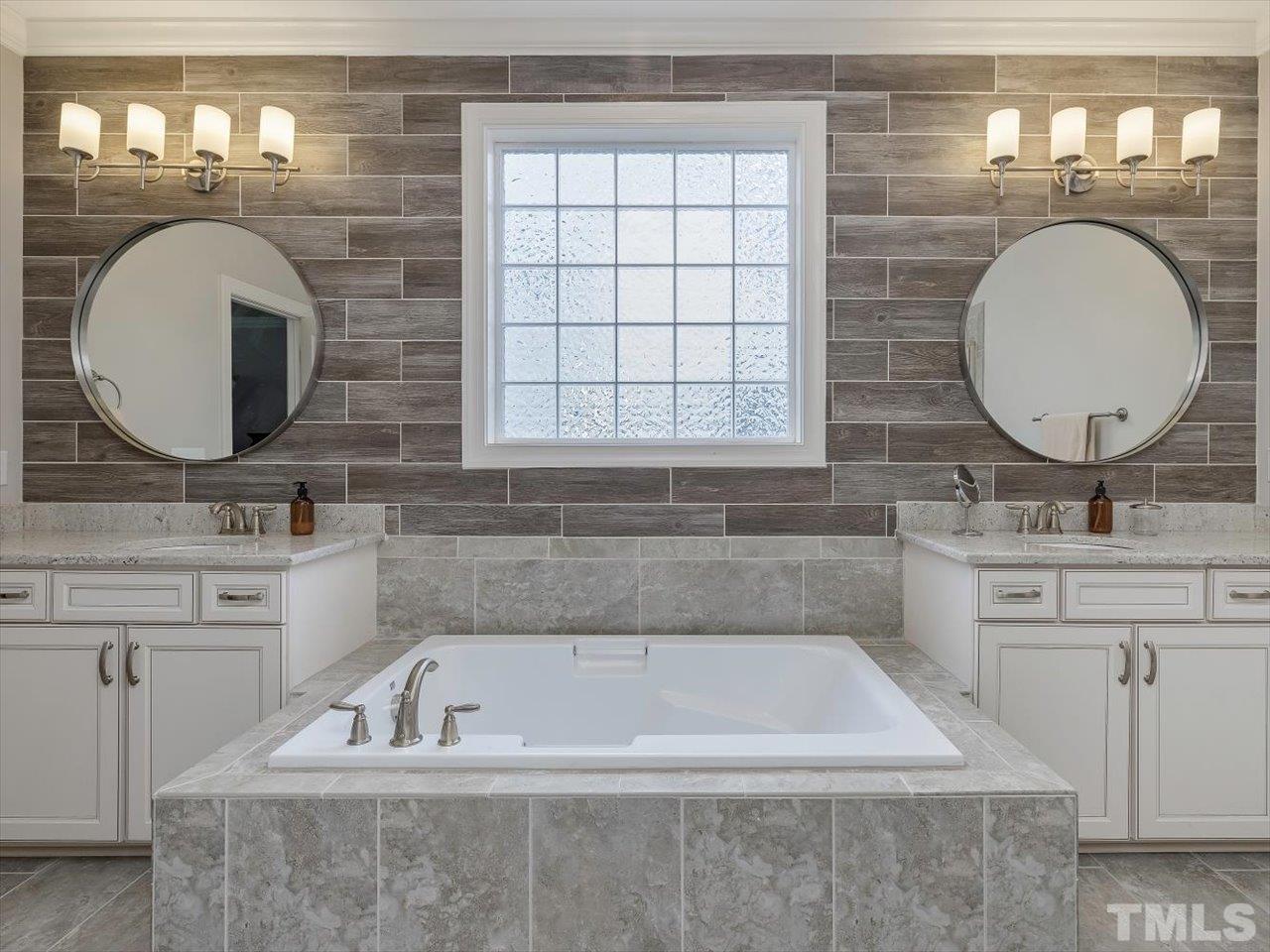 604 Chapanoke Road Raleigh, NC 27603 - Photo 15 of 30 a bathroom with a tub a sink and a mirror