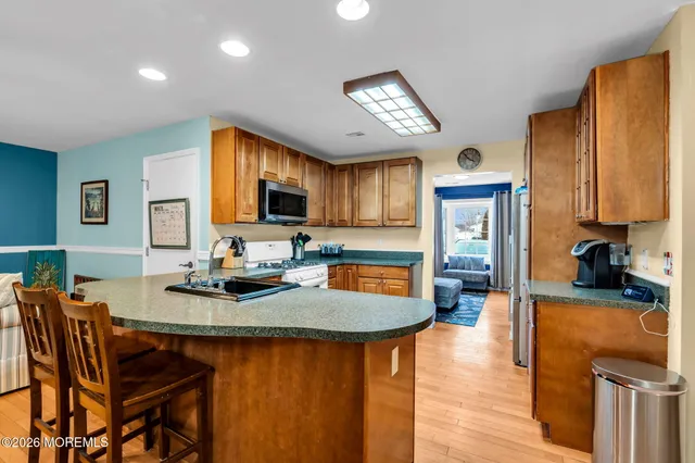 a kitchen with sink a refrigerator and chairs