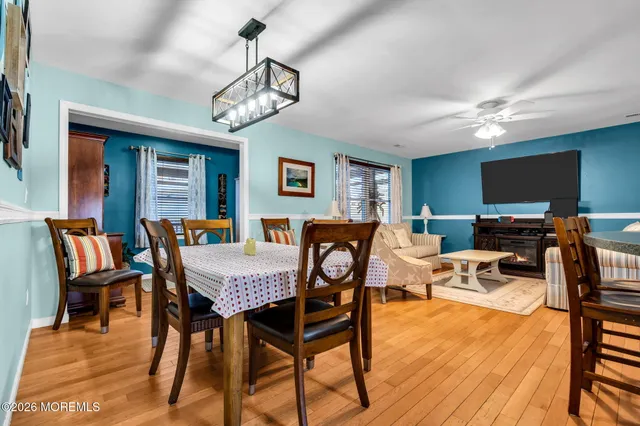 a view of a dining room with furniture a chandelier and wooden floor