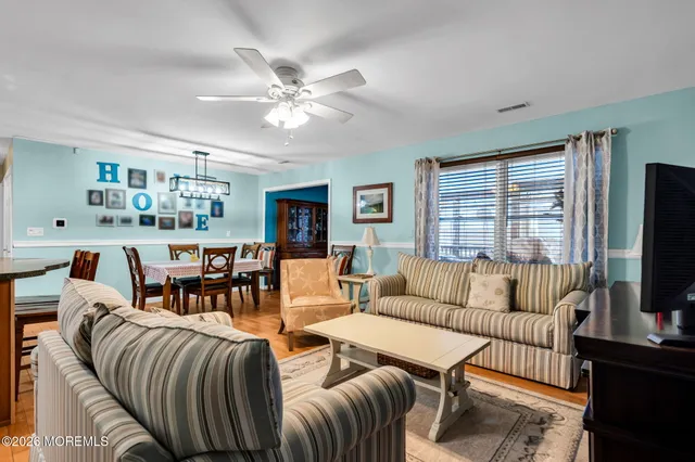 a living room with furniture a flat screen tv and a window