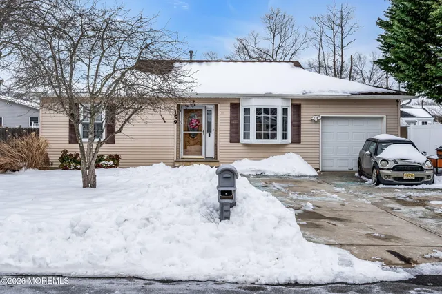 a front view of a house with a yard covered in snow