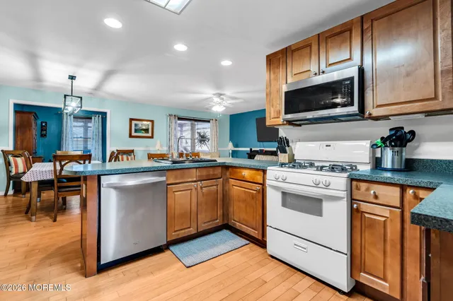 a kitchen with stainless steel appliances granite countertop a stove a sink and a microwave