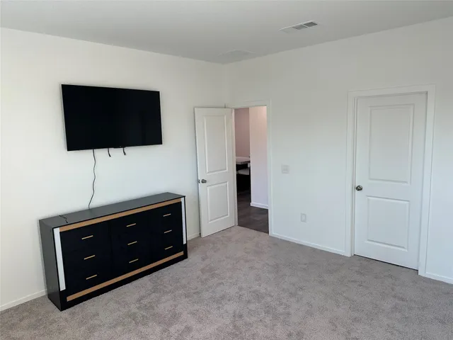 a living room with flat screen tv and floor to ceiling window