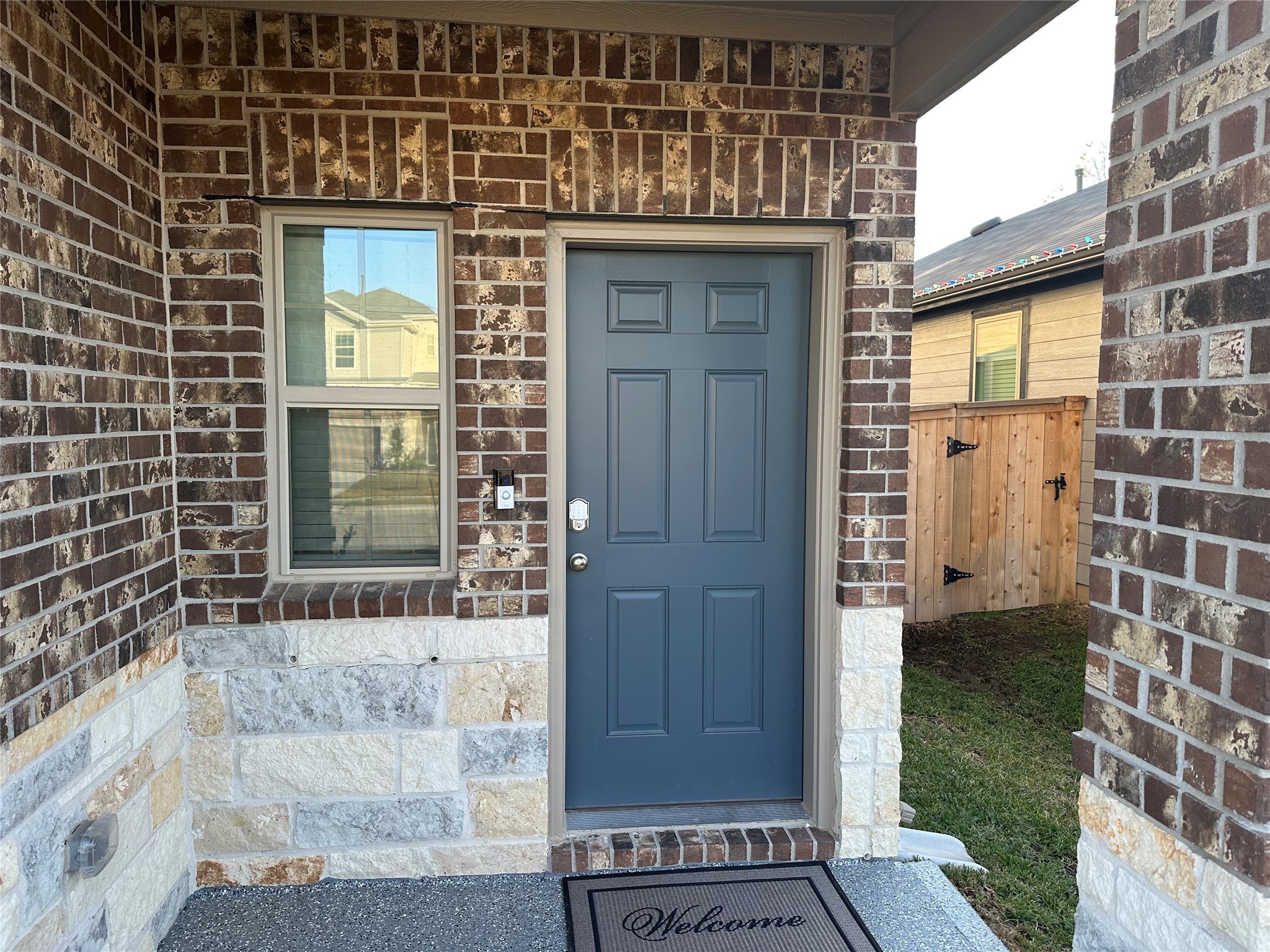 16936 Juniper Blossom Bend Conroe, TX 77302 - Photo 2 of 28 a view of a brick house with a red door and a wooden bench