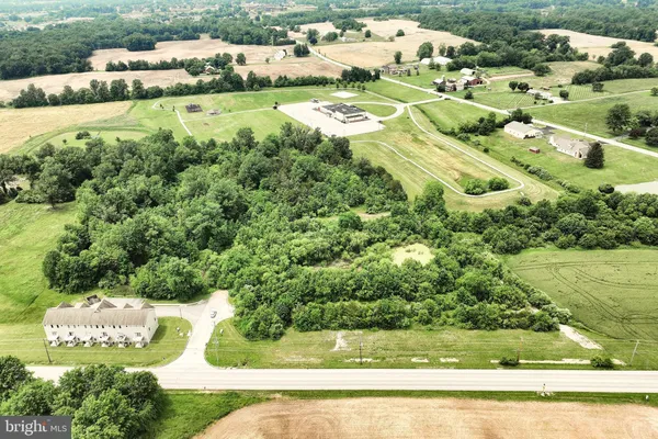 an aerial view of residential houses with outdoor space and trees