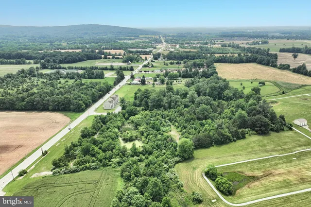 an aerial view of residential houses with outdoor space and trees