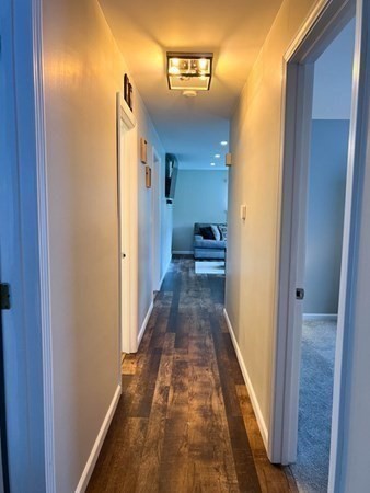 198 Senator Street Springfield, MA 01129 - Photo 8 of 27 a view of a hallway with wooden floor and a bathroom