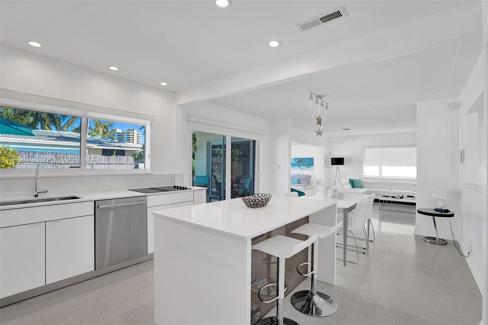 3411 Dover Road Pompano Beach, FL 33062 - Photo 6 of 64 a kitchen with stainless steel appliances a table and chairs in it