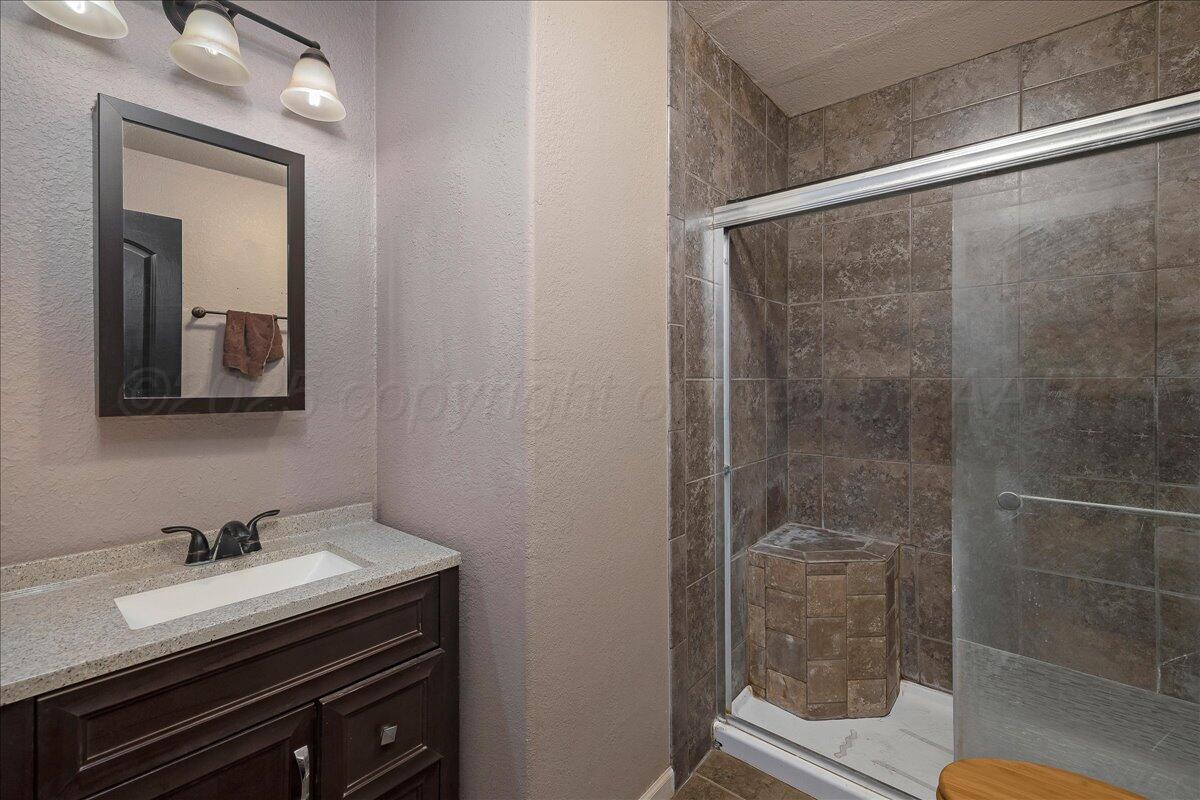 4317 Cline Road Amarillo, TX 79110 - Photo 11 of 18 a bathroom with a sink and a mirror