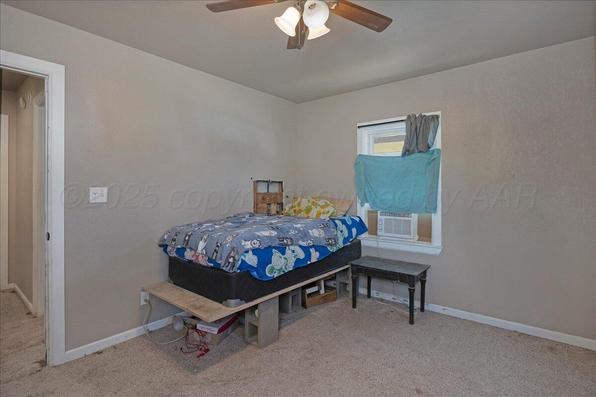 4317 Cline Road Amarillo, TX 79110 - Photo 13 of 18 a bedroom with a bed and a chandelier