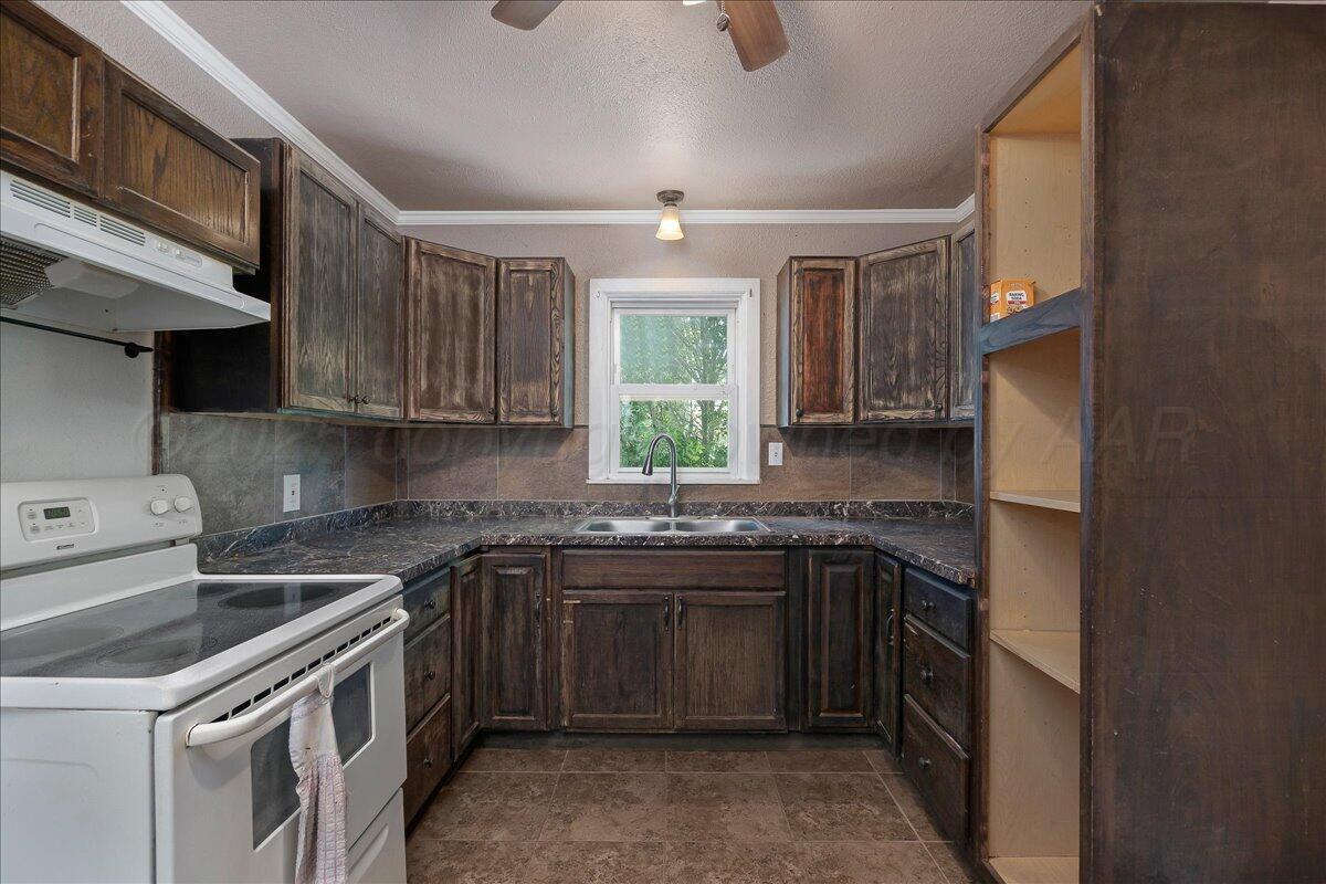 4317 Cline Road Amarillo, TX 79110 - Photo 6 of 18 a kitchen with a sink stove and cabinets