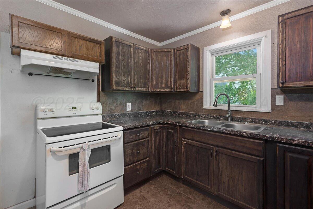 4317 Cline Road Amarillo, TX 79110 - Photo 7 of 18 a kitchen with a stove a sink and a window