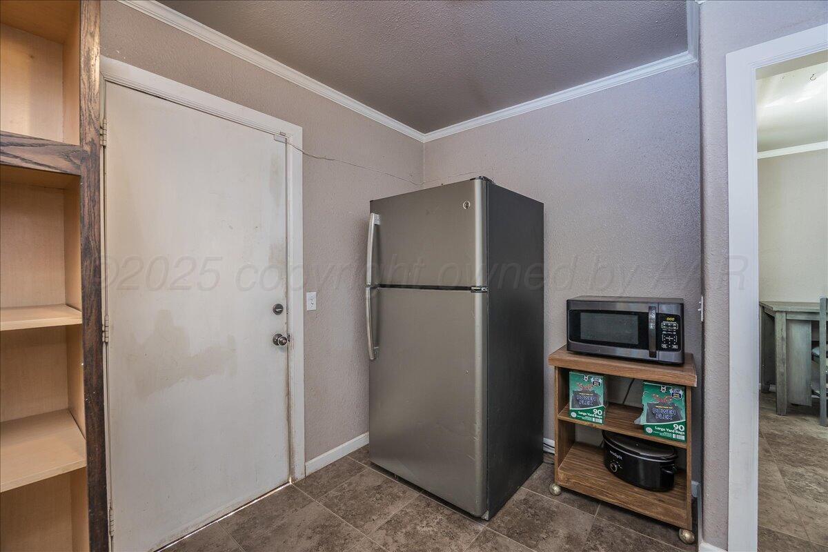 4317 Cline Road Amarillo, TX 79110 - Photo 8 of 18 a view of a refrigerator in kitchen and an empty room