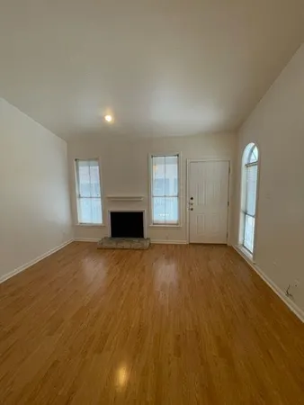 an empty room with windows and fireplace