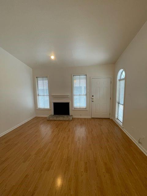 2529 Rio Grande Street, Unit 64 Austin, TX 78705 - Photo 2 of 9 Unfurnished living room with a fireplace with raised hearth and light wood finished floors