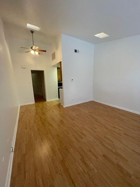 2529 Rio Grande Street, Unit 64 Austin, TX 78705 - Photo 3 of 9 Unfurnished room with wood finished floors and a ceiling fan
