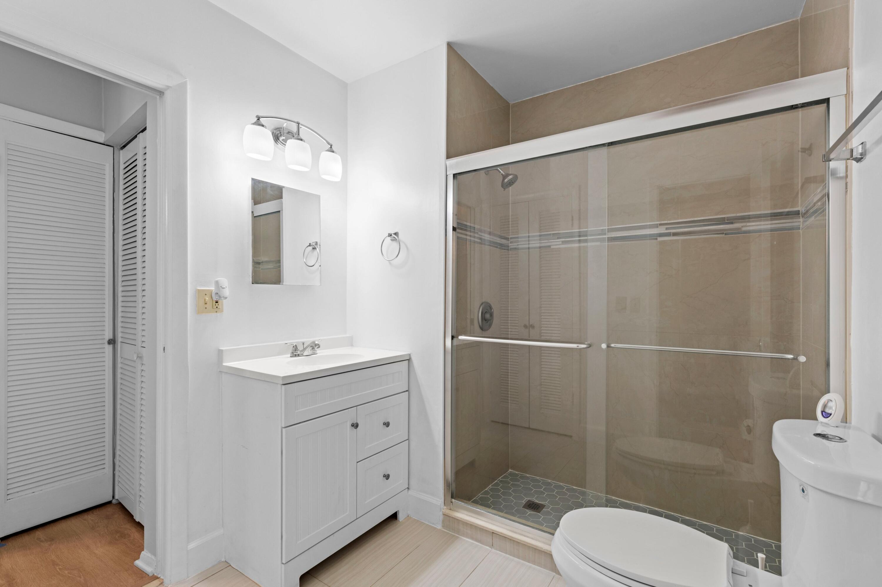 8555 Bella Vista Drive, Unit 86 Boca Raton, FL 33433 - Photo 12 of 48 a bathroom with a shower sink vanity mirror and toilet