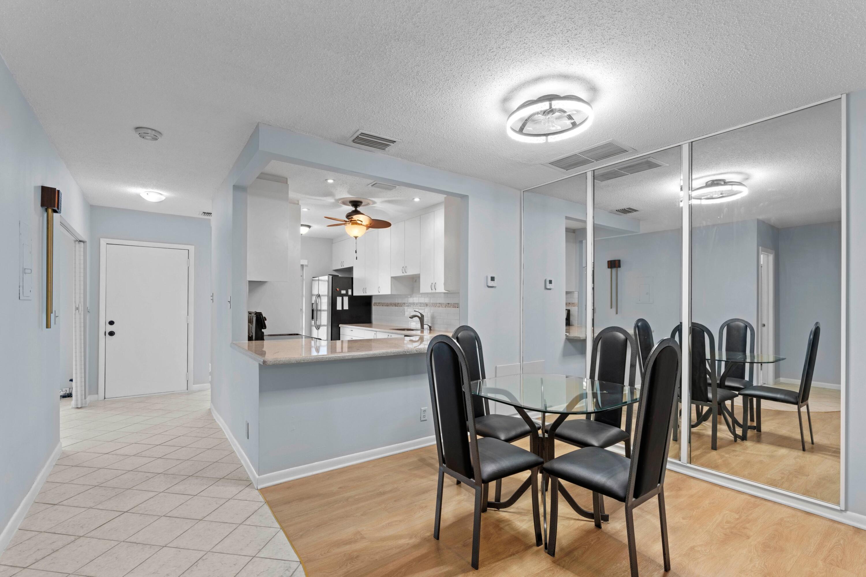8555 Bella Vista Drive, Unit 86 Boca Raton, FL 33433 - Photo 5 of 48 a view of a dining room with furniture and chandelier