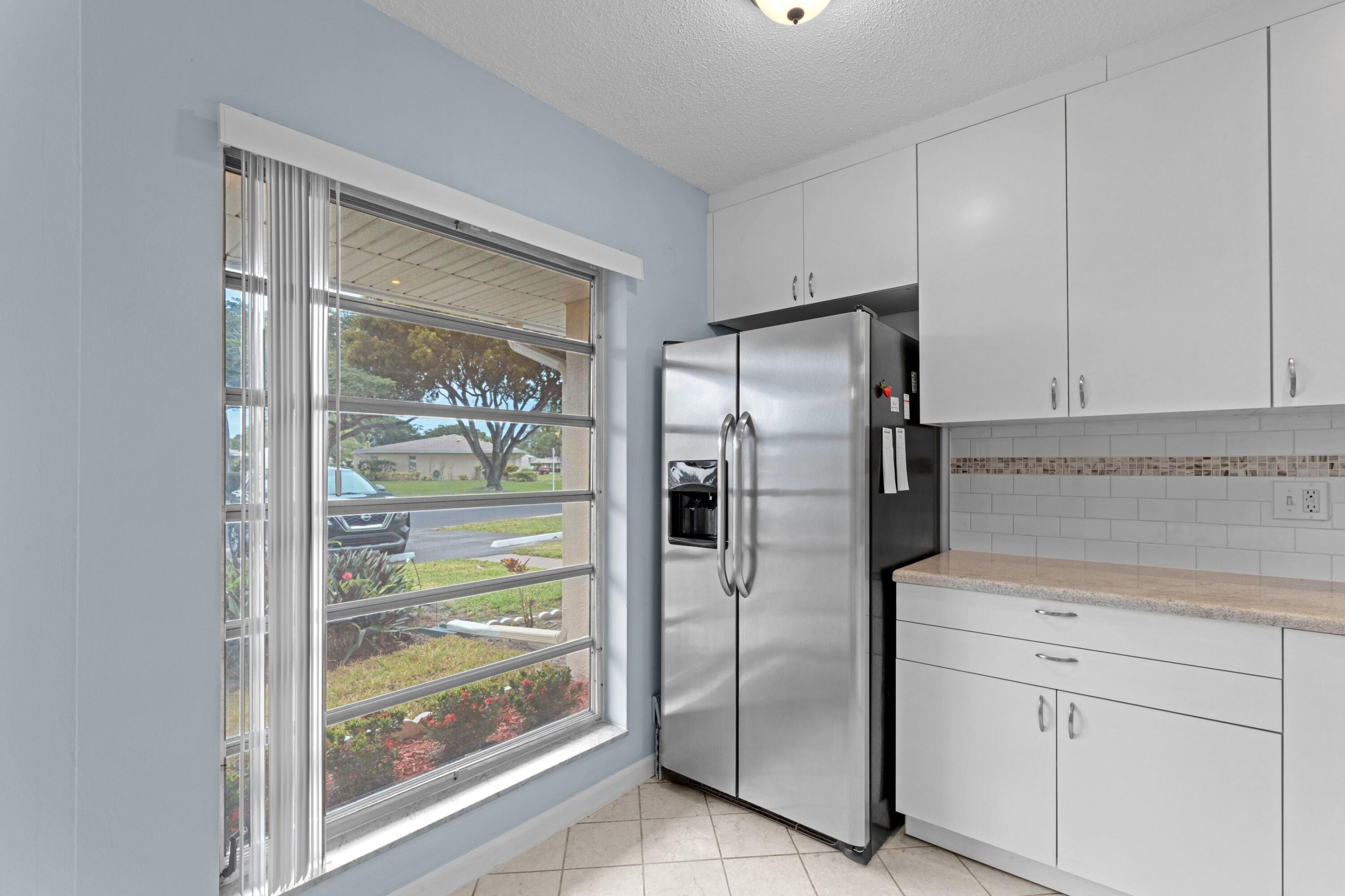 8555 Bella Vista Drive, Unit 86 Boca Raton, FL 33433 - Photo 8 of 48 a kitchen with stainless steel appliances a refrigerator and a sink