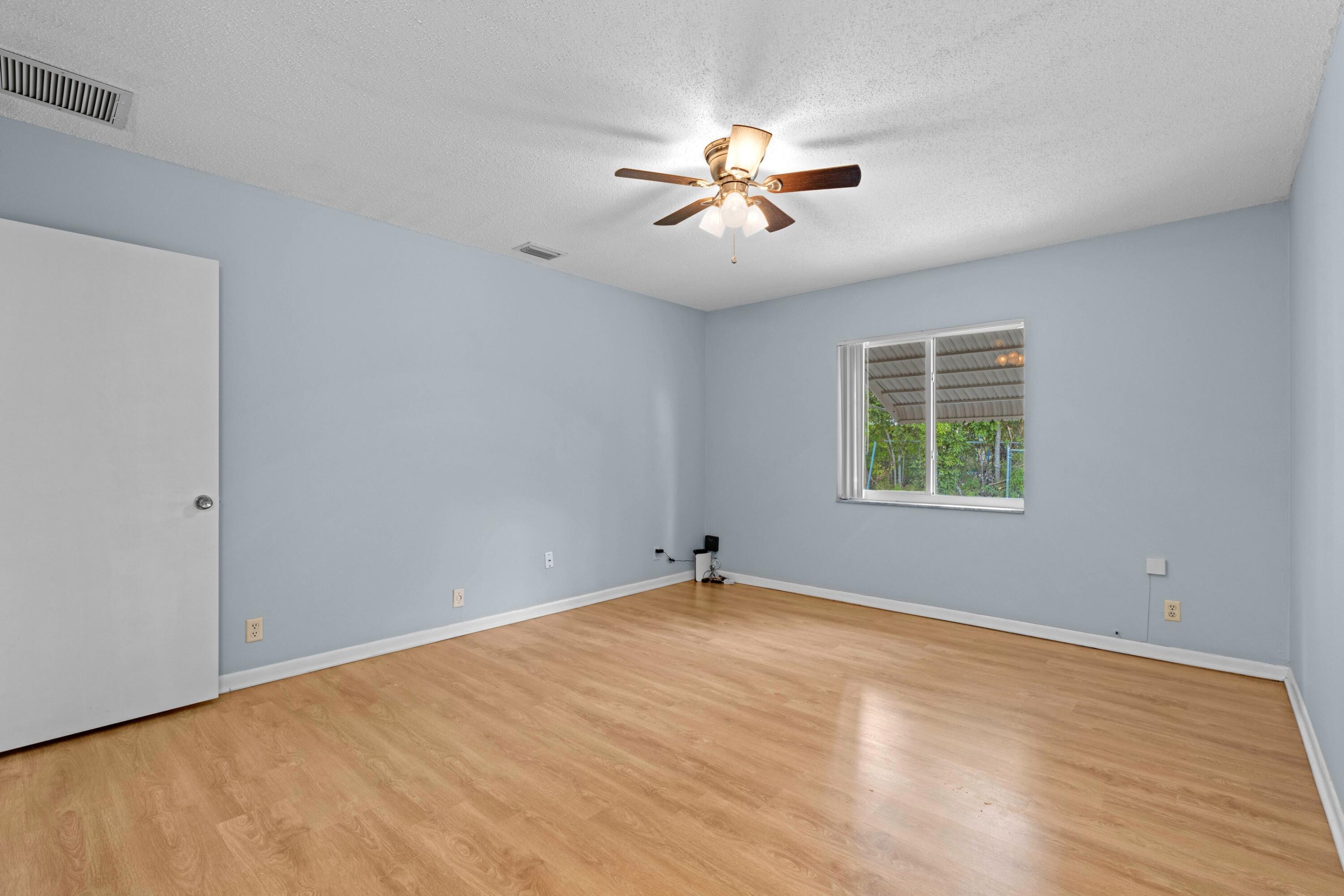 8555 Bella Vista Drive, Unit 86 Boca Raton, FL 33433 - Photo 10 of 48 a view of an empty room with chandelier fan and a window