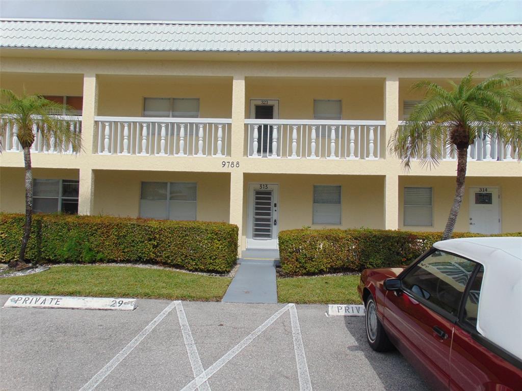9788 Marina Boulevard, Unit 313 Boca Raton, FL 33428 - Photo 19 of 70 a front view of a house with a yard and garage