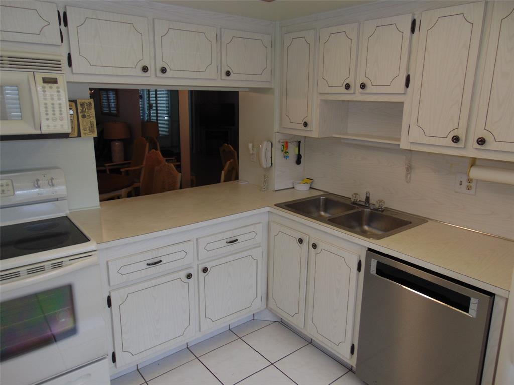 9788 Marina Boulevard, Unit 313 Boca Raton, FL 33428 - Photo 22 of 70 a kitchen with white cabinets and appliances