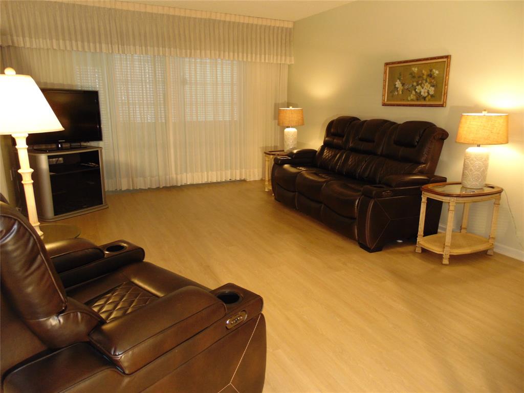 9788 Marina Boulevard, Unit 313 Boca Raton, FL 33428 - Photo 35 of 70 a living room with furniture and a flat screen tv