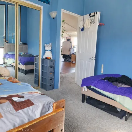 a bedroom with a bed a books bucket with a desk and chair