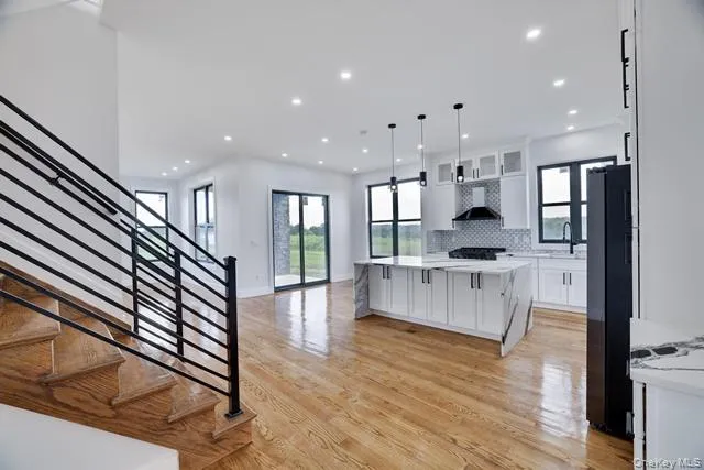 a large white kitchen with lots of counter space wooden floor and appliances