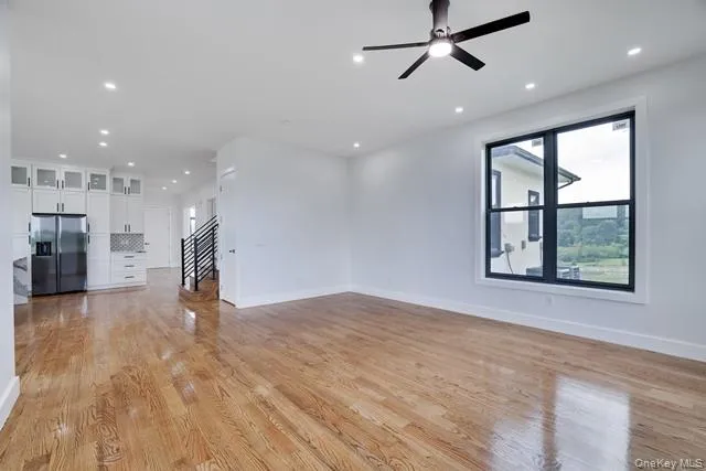 a view of empty room with wooden floor and windows