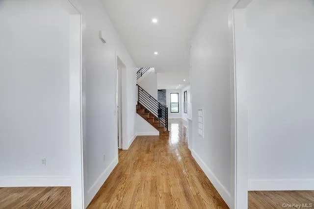 a view of a hallway with wooden floor and staircase