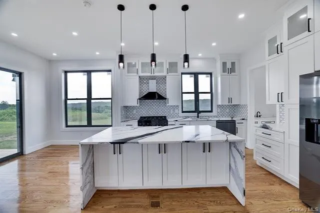 a kitchen with stainless steel appliances kitchen island granite countertop a sink and a cabinets
