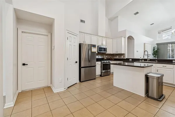 a kitchen with a sink and a large mirror