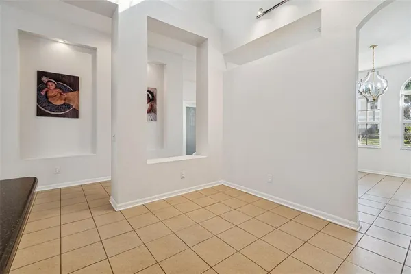 a kitchen with stainless steel appliances a stove a refrigerator a stove a dining table and chairs with wooden floor