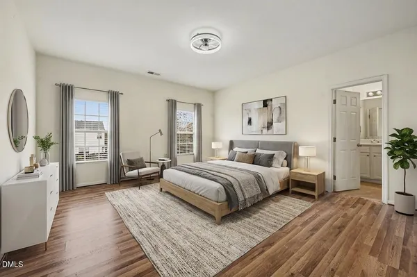 a spacious bedroom with a bed and wooden floor