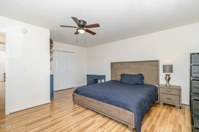 a spacious bedroom with a bed and a ceiling fan