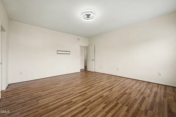 a view of an empty room with wooden floor