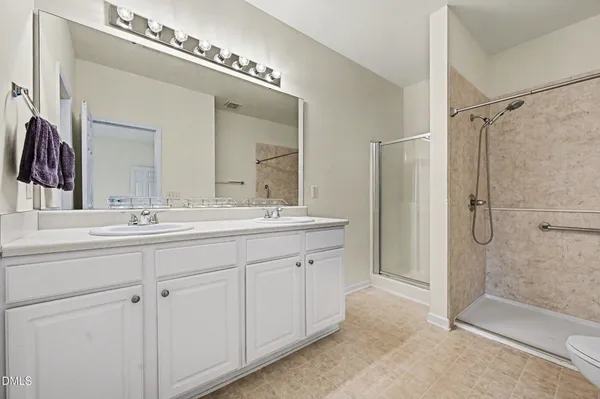 a bathroom with a double vanity sink mirror double and shower