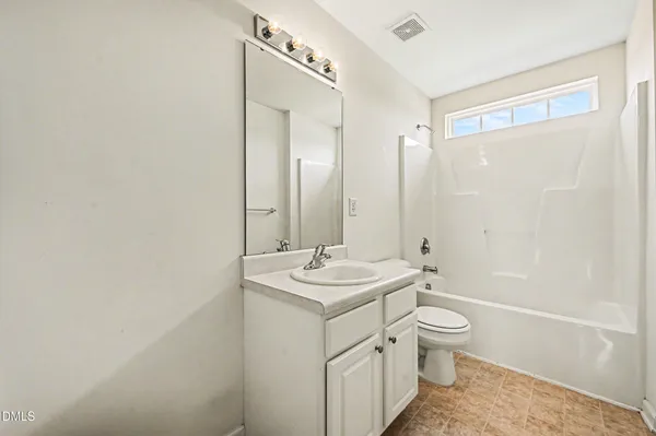 a bathroom with a granite countertop sink a toilet and shower