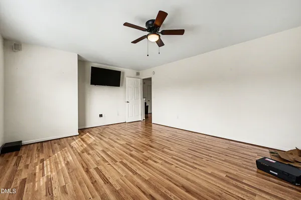 a view of room with ceiling fan and wooden floor