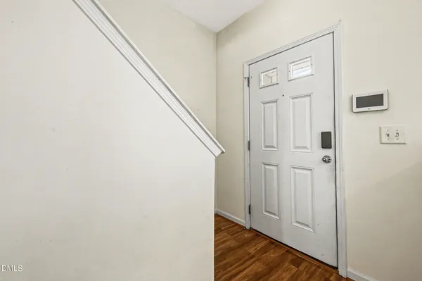 a view of a hallway with wooden floor and entryway