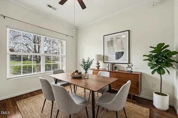 a dining room with furniture potted plants and wooden floor